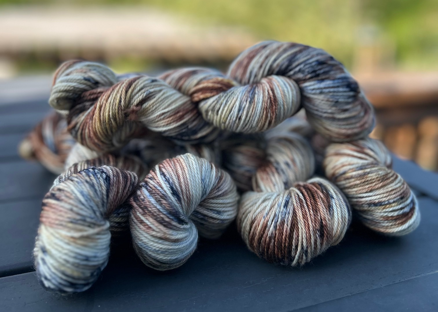 Braided skein of multicolored yarn on a surface with a blurred natural background